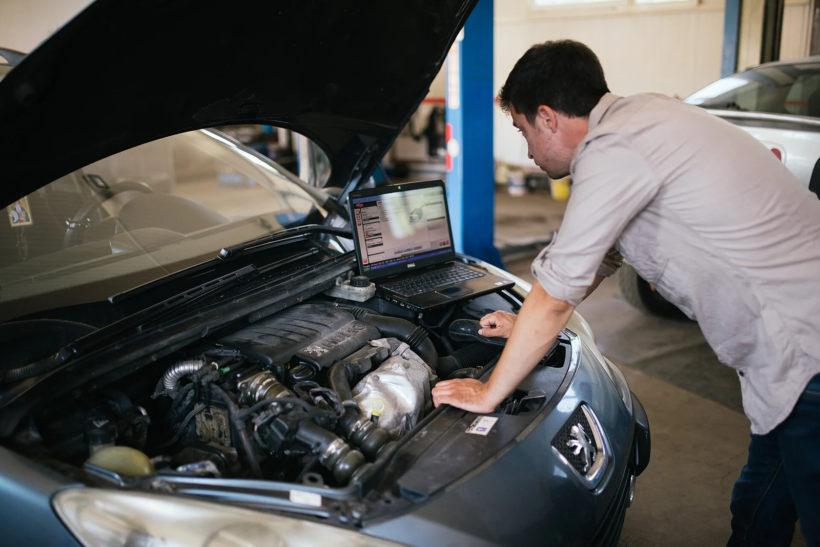Diagnostic automobile à l’aide d’un ordinateur dans un garage.
